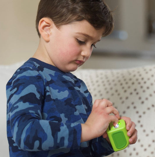 A little boy on the couch clipping his own nails with the child size Lil Nipper.