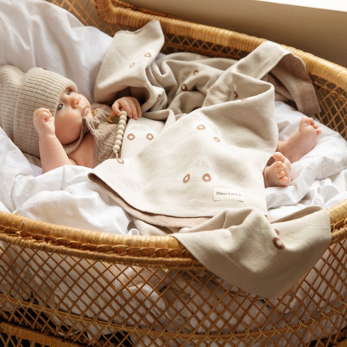 Baby in a wicker basket with a blanket
