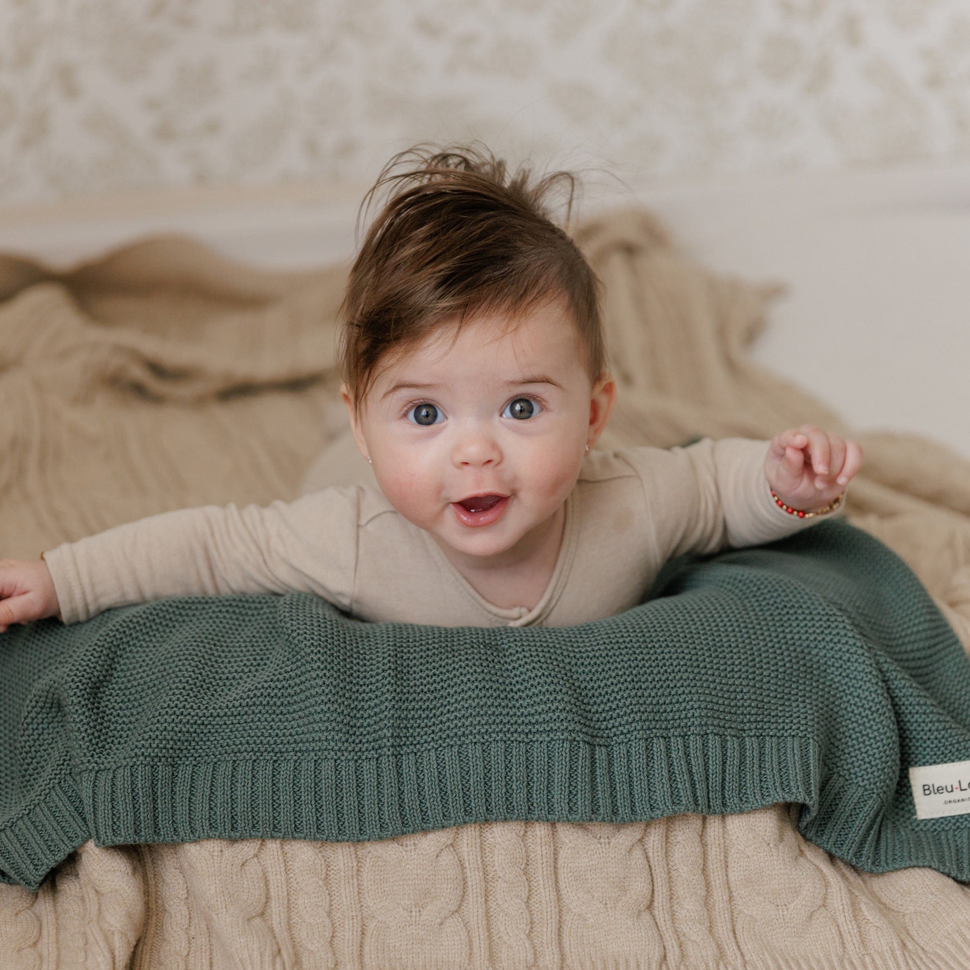 Baby lying on a green Blue-La-La blanket