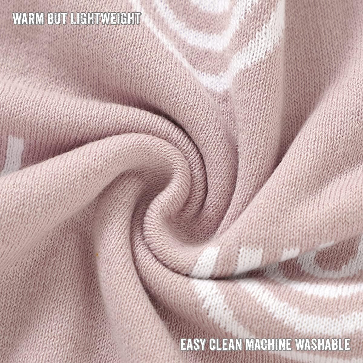 Close-up of pink fabric with text indicating warmth, light weight, and machine washability.