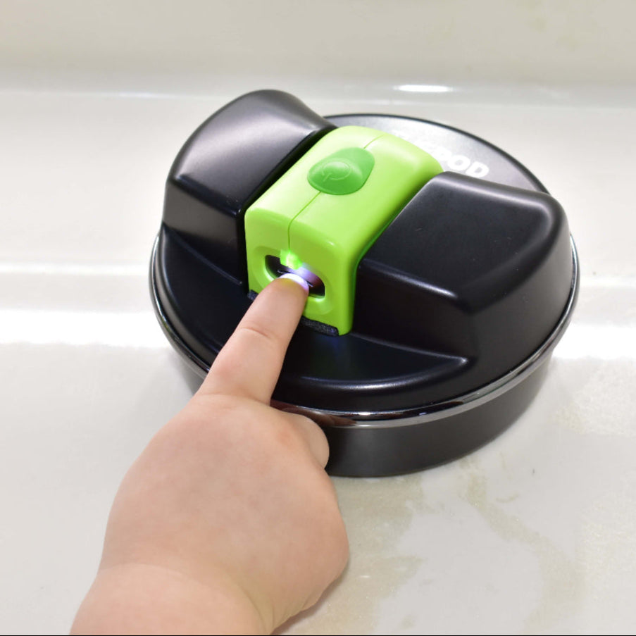 Image of school-aged hand using the Lil Nipper and POD, inserting fingernail into slot and POD is resting on a table.