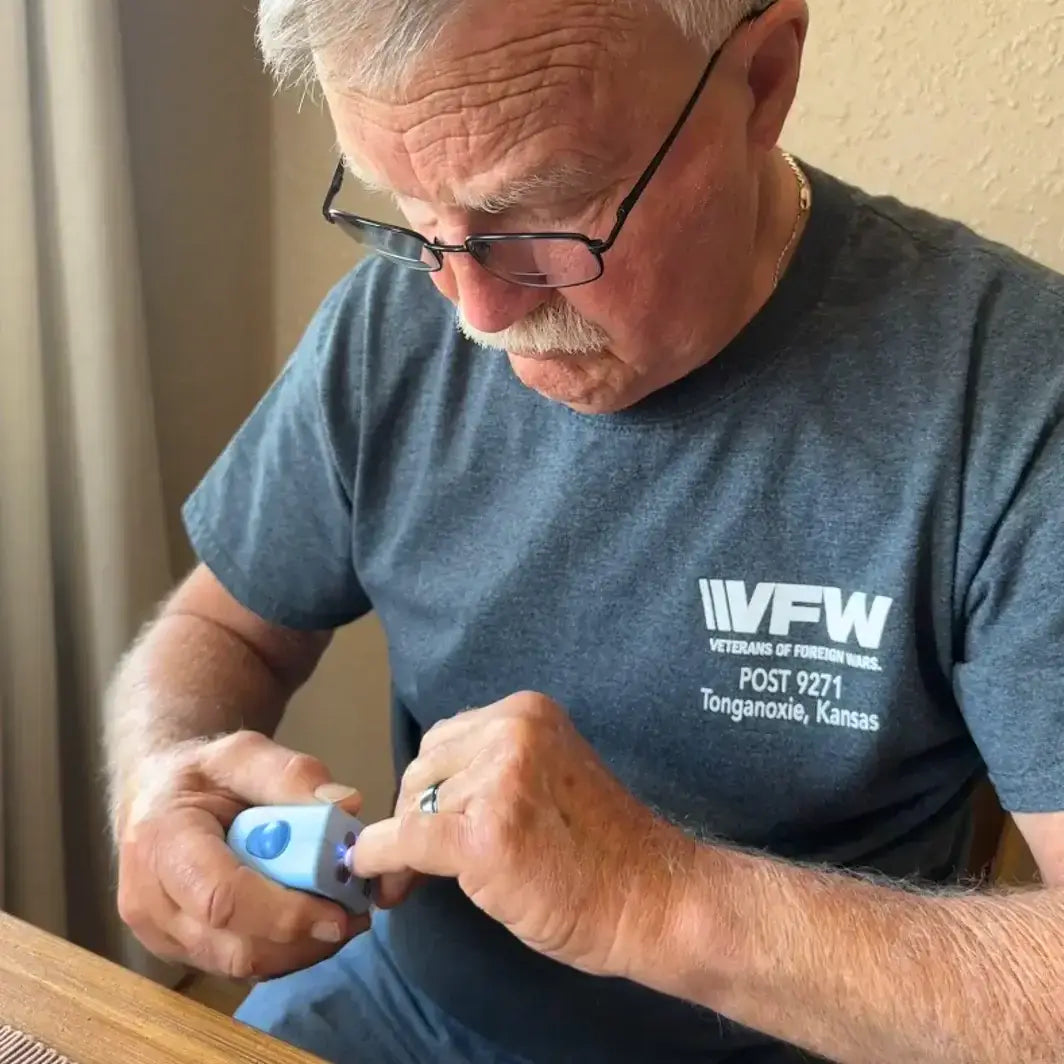 A retired veteran wearing a VFW shirt using Lil Nipper Adult size nail clipper in blue color.