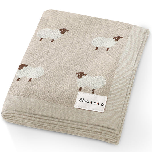 Folded blanket with sheep pattern and Bleu-La-La label on a white background