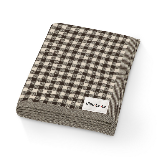 Folded checkered blanket with 'Bleu La La' label on a white background. Checkered knit baby blanket with textured checkered pattern in soft fabric