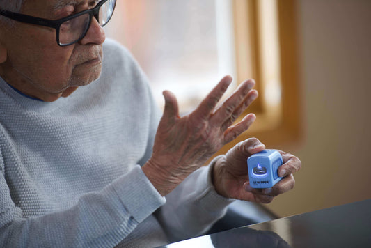 An elderly man holding up his hands and the other hand he is holding a Lil Nipper Adult size in blue.