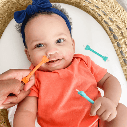 Parent using oogiebear orange booger picker with dual-ended scoop and loop tips and bear safety bumper