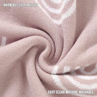 Close-up of pink fabric with text indicating warmth, light weight, and machine washability.