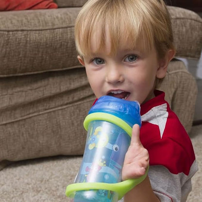 Child holding a colorful sippy cup with EaZyHold grips in front of a beige couch.