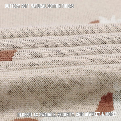 Close-up of beige swaddle blanket with text about buttery soft natural cotton fibers and its uses.