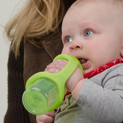 Baby holding a green sippy cup with EaZyHold grips and a person partially visible in the background.