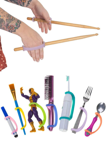 Colorful EazyHold grips with a variety of household items including a brush, fork, spoon, paint brush, marker, and toy figurine.