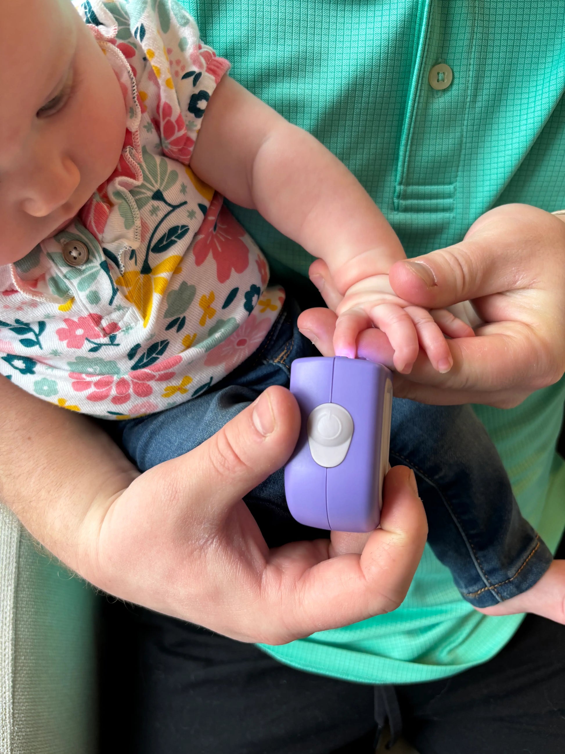 Baby getting her nails trimmed safely by Lil Nipper electric nail clipper.