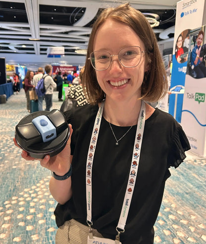 Girl holding The Pod with Adult Lil Nipper and smiling. She has one arm. 