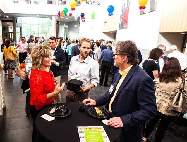 Melanie McMullen and two gentlemen discussing ClipDifferent at an event. 