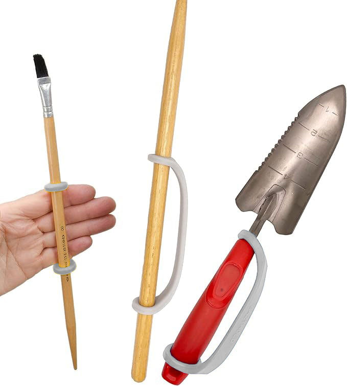 Hand holding a pen with a tool holder, showing a trowel and brush using EazyHold grips.