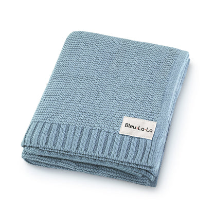 Folded blue knit blanket with a visible Blue-La-La label on a white background