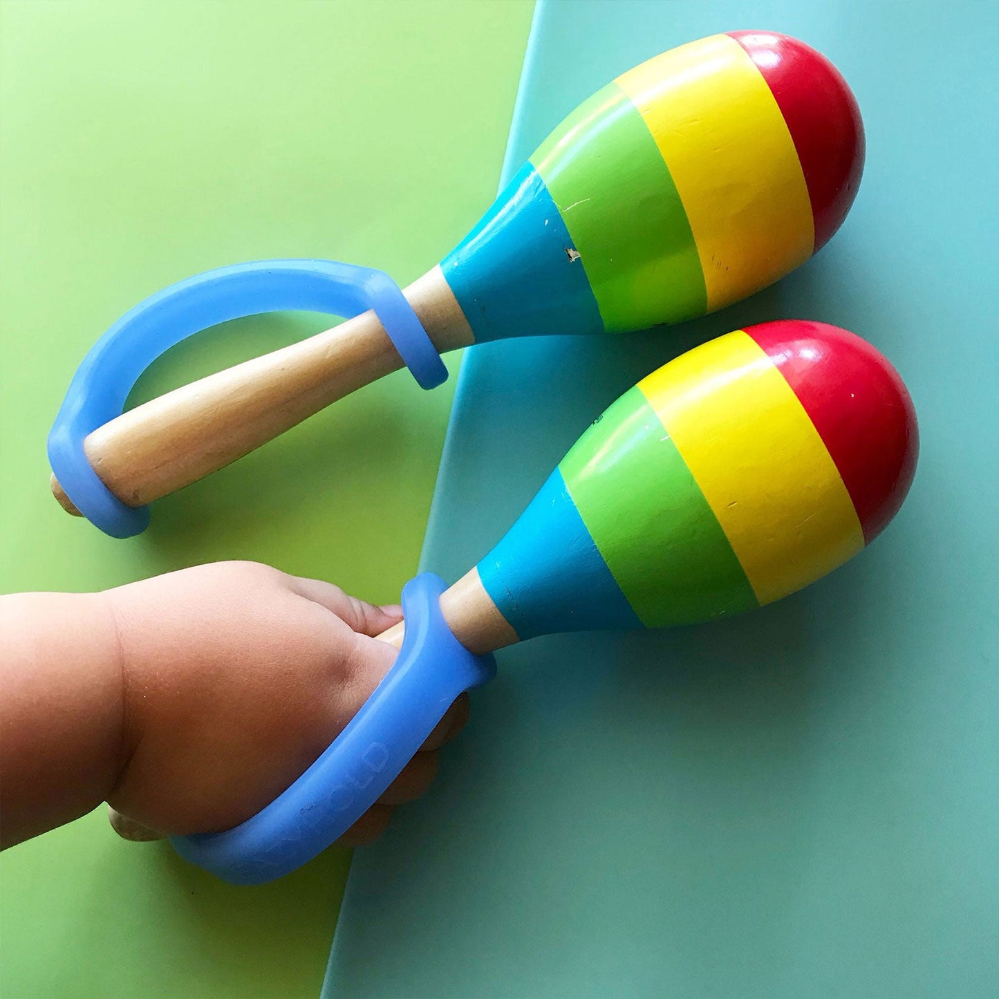 Colorful maracas with blue handles on a green background