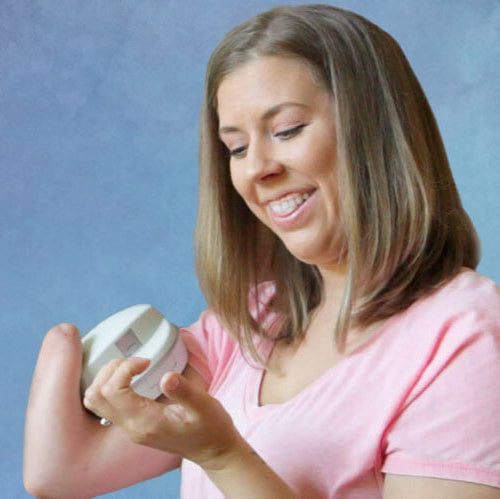 Woman holding a Pro Nail Clipper and has one one hand. Standing against a textured purple background