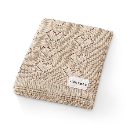Beige knitted blanket with butterfly pattern and 'Bleu La La' label on a white background