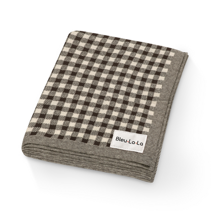 Folded checkered blanket with 'Bleu La La' label on a white background. Checkered knit baby blanket with textured checkered pattern in soft fabric