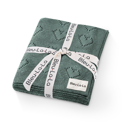 Green knitted blanket with a white ribbon and 'Bleu La La' label on a white background