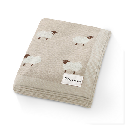 Beige baby blanket with sheep pattern and Bleu La La label on a white background