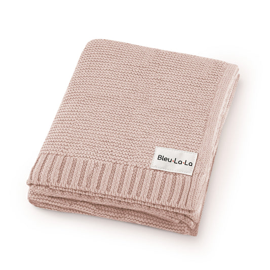 Folded pink Blue-La-La knitted blanket with a visible brand label on a white background