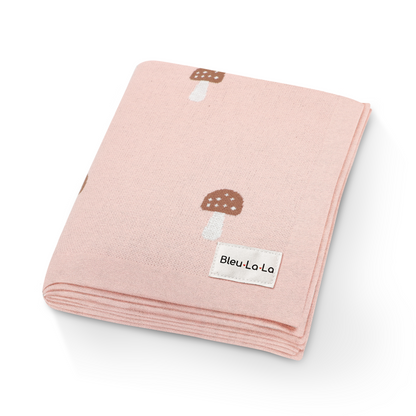 Close-up of luxury pink knit mushroom swaddle blanket showing soft texture and mushroom details