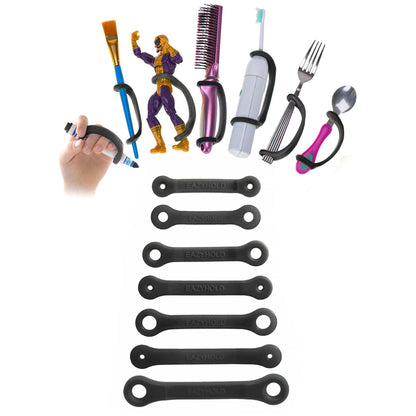 Black EazyHold grips with a variety of household items including a brush, fork, spoon, paint brush, marker, and toy figurine.